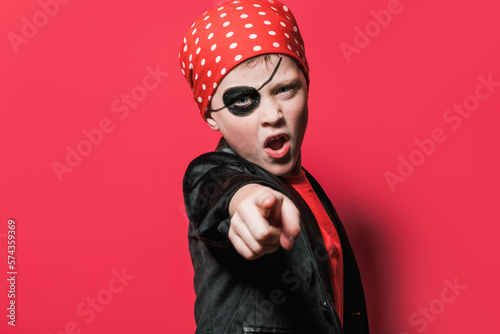 Adorable boy in pirate costume pointing at camera photo