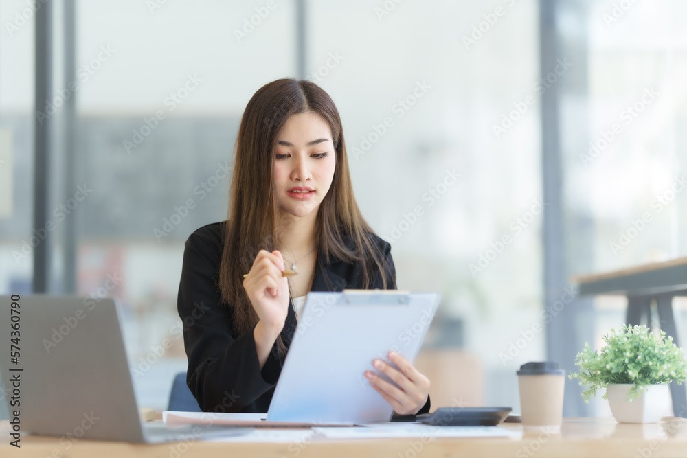 Attractive asia busy business woman consultant auditor working at modern office with balance sheet accounting bookkeeping documents. Account verification to prevent fraud bribery. Attractive asia busy business woman consultant auditor working at modern office with balance sheet accounting bookkeeping documents. Account verification to prevent fraud bribery.
