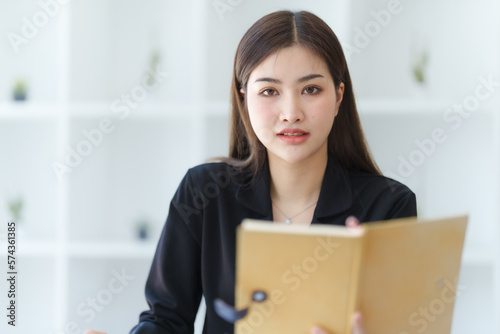 Attractive asia busy business woman consultant auditor working at modern office with balance sheet accounting bookkeeping documents. Account verification to prevent fraud bribery.