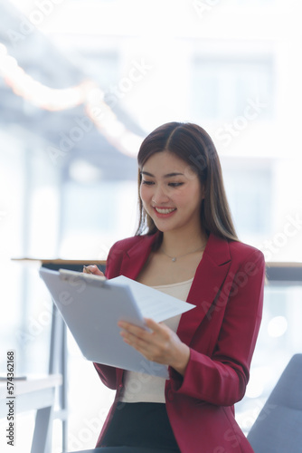 Attractive asia busy business woman consultant auditor working at modern office with balance sheet accounting bookkeeping documents. Account verification to prevent fraud bribery. © M+Isolation+Photo