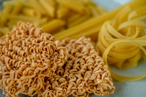dried Instant noodles on white mulberry paper background. Instant noodles and pasta are wheat flour products call junk convenience food. Chinese and Japanese oriental noodle.