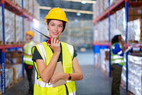 Happy cheerful caucasian white female warehouse worker checking an items or stock inventory in warehouse. Professional occupation in logistic industrial concept. © DG PhotoStock