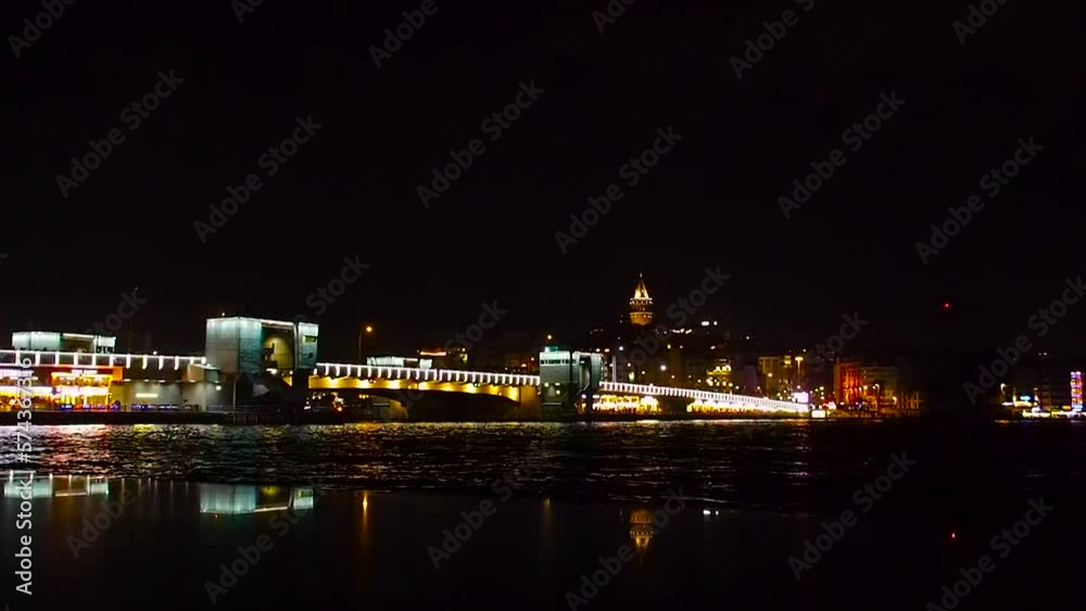 Night Istanbul. View of the Bosphorus. The bridge across the strait is decorated with bright lanterns and lights. Above the bridge you can see the Galata Tower. urban landscape Night Istanbul. View of the Bosphorus. The bridge across the strait is decorated with bright lanterns and lights. Above the bridge you can see the Galata Tower. urban landscape