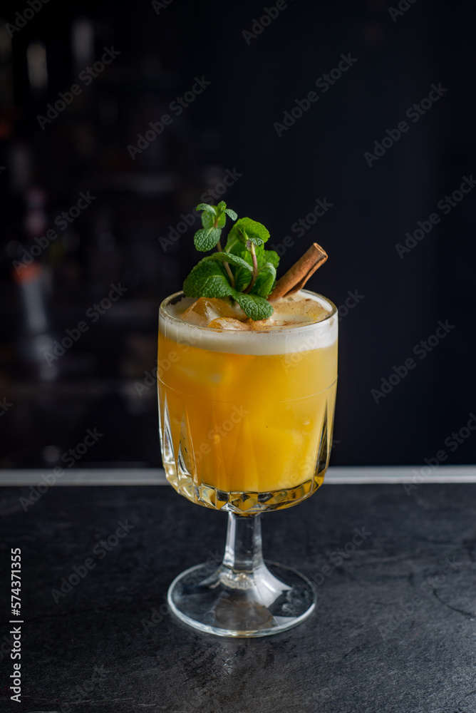Yellow cocktail with foam on a dark background Yellow cocktail with foam on a dark background