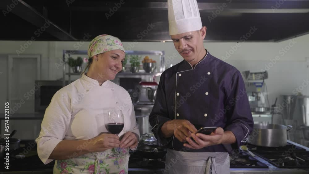 Video Stock Couple of chefs drinking wine in the kitchen after a day at ...