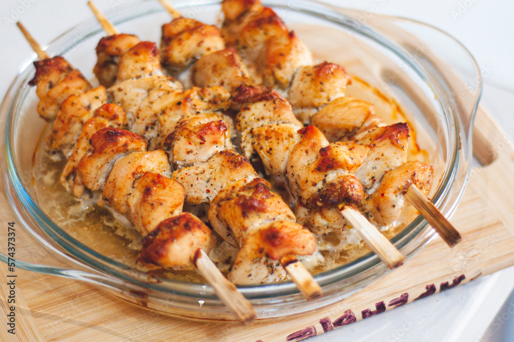 Chicken skewers on skewers close-up. Chicken skewers at home, cooked in the oven. Chicken skewers - grilled meat on wooden background.