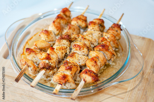 Chicken skewers on skewers close-up. Chicken skewers at home, cooked in the oven. Chicken skewers - grilled meat on wooden background.