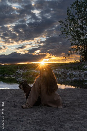 Dog with owner on beach sunset