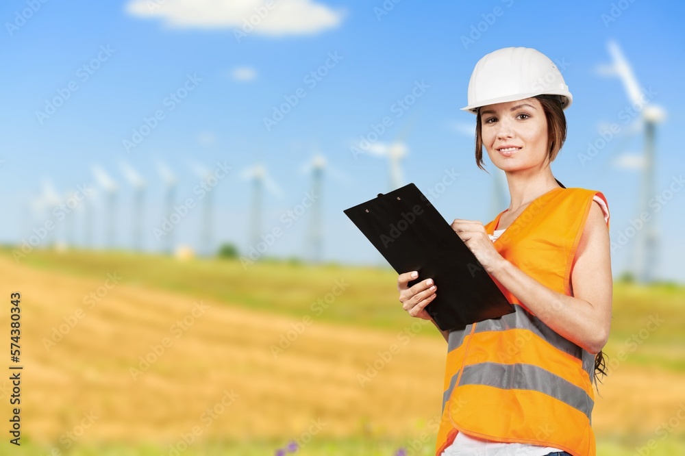 Engineer working at windmill farm, clean energy concept Engineer working at windmill farm, clean energy concept
