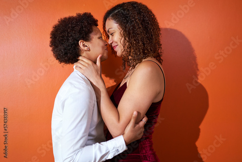 Portrait happy lesbian couple with curly hair smiling face to face photo