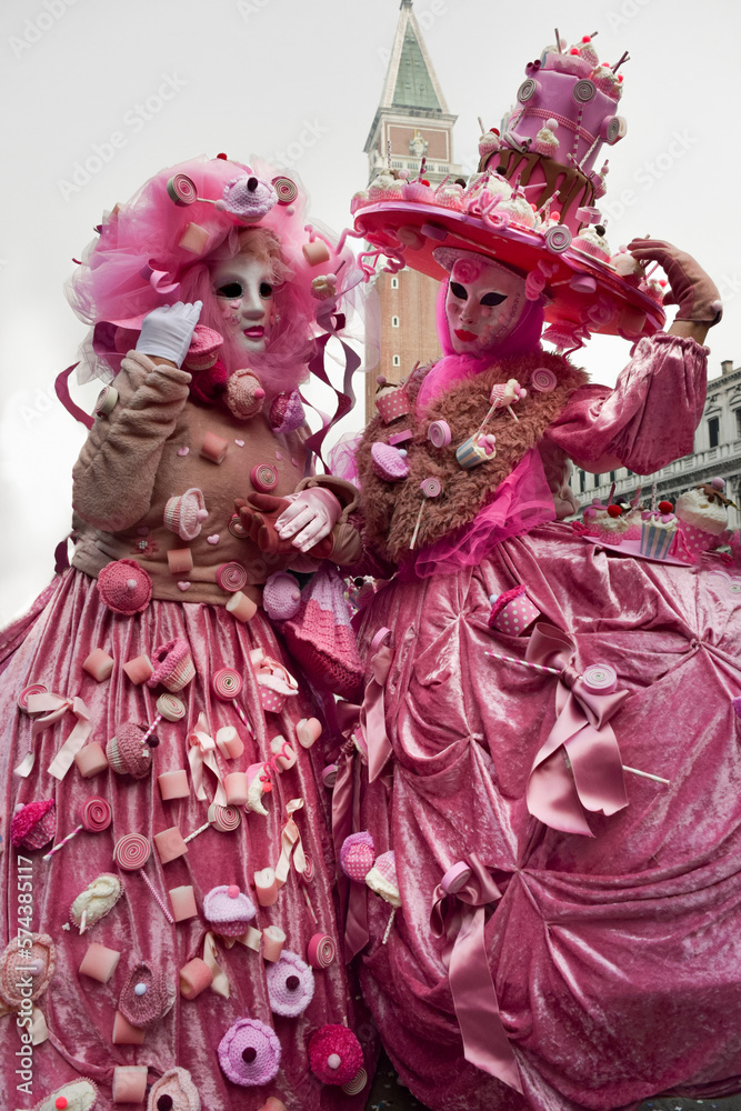 Couple of people dressed up for the Venice Carnival wearing pink sweets