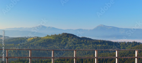 Panoramic view from the terrace on the Carpathian mountain range. Hoverla and Petros mountain peaks in the background.