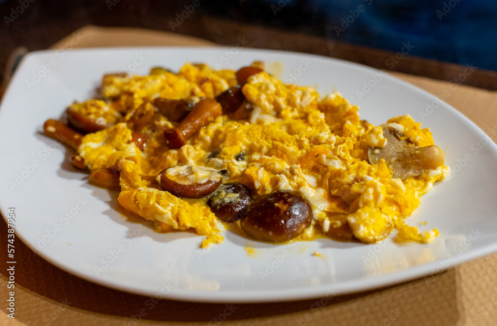 Homemade scrambled eggs with forest mushrooms