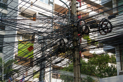 Chaos of cables and wires in Bangkok, Thailand, electric and telephone wires wound on a lamppost