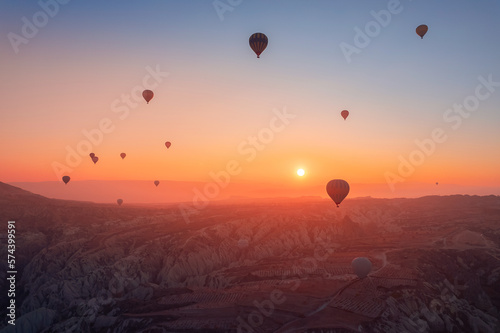Amazing sunrise Cappadocia with set colorful hot air balloons fly in pink sky with first sun light. Turkey travel Concept, aerial view