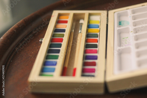 close up of watercolor art set with paintbrush in a wood box