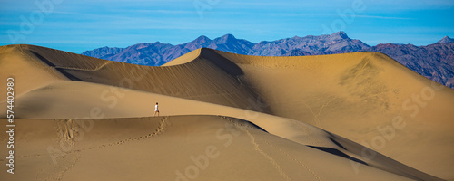 girl in white dress lost in the desert  walking on large sand dunes in mesquite flat sand dunes in death valley national park  california  usa