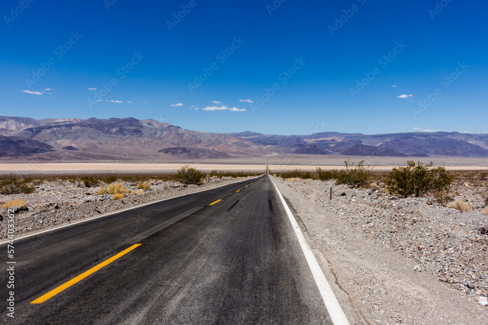 State Route 190 crossing Panamint Valley in Death Valley National Park, California, United States. Empty desert road in Death Valley with clear blue sky. State Route 190 crossing Panamint Valley in Death Valley National Park, California, United States. Empty desert road in Death Valley with clear blue sky.