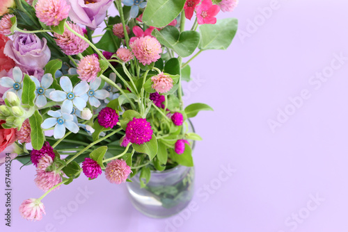 Top view image of pink and purple flowers composition over pastel background