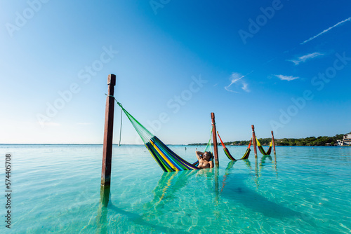 Man on hammock in Bacalar lagoon Mexico photo