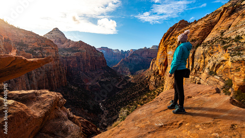 hiker girl admires spring sunset in zion national park, amazing sunset over mighty canyon in utah, usa