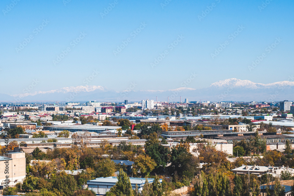 View of Tashkent, the outskirts of the city, the country of Uzbekistan. View of the mountains and residential buildings from the window. Sunny day.