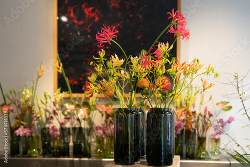 Decorative glass vases with flowers. flame lilis (Gloriosa superba) in the foreground. photo