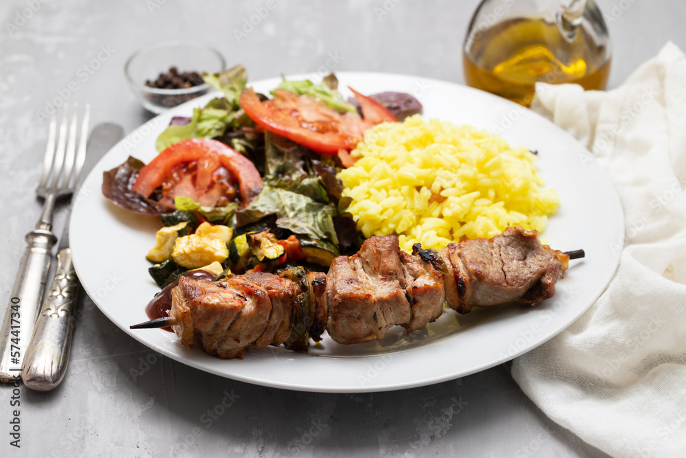 Grilled meat on stick, vegetables, salad and boiled rice