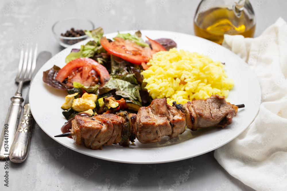 Grilled meat on stick, vegetables, salad and boiled rice Grilled meat on stick, vegetables, salad and boiled rice