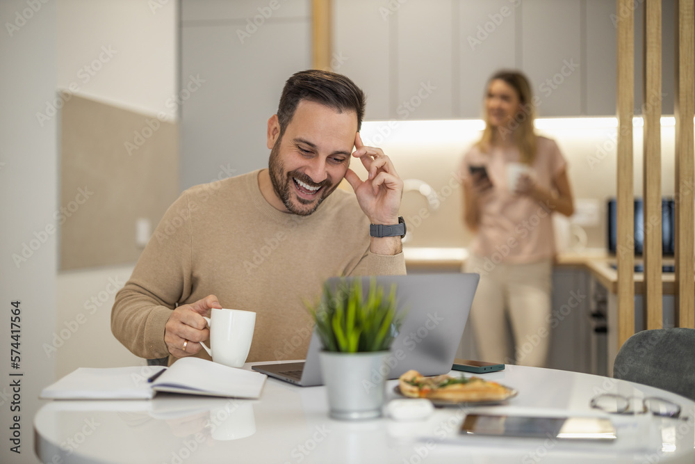 Smiling businessman working on laptop at home office Smiling businessman working on laptop at home office
