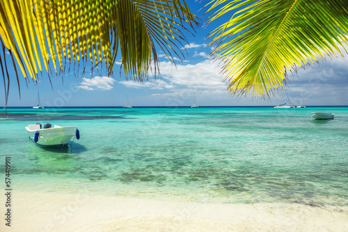 Beautiful caribbean sea and boat on the shore of exotic tropical island, panoramic view from the beach photo