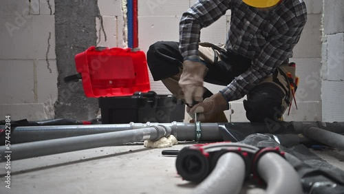 Professional Plumber Installing Pipeline Inside Newly Built House