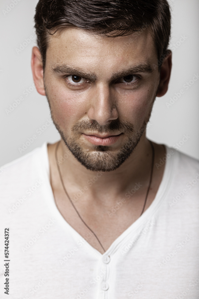 Fashion male studio portrait. Caucasian white guy with stubble. Large portrait of a guy in a white T-shirt. Fashion male studio portrait. Caucasian white guy with stubble. Large portrait of a guy in a white T-shirt.