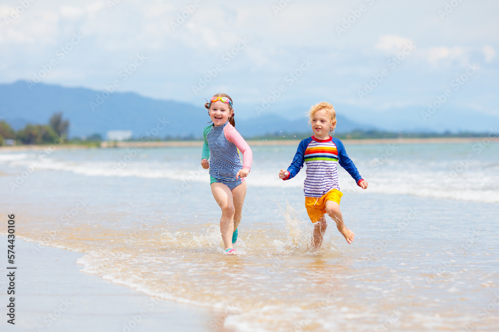 Kids on tropical beach. Children playing at sea.