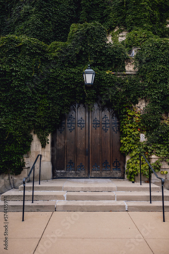 University of Chicago, traditional campus scene with wooden door entrance, staircase and lamp