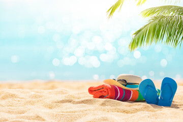 Summer holiday background with flip flops and palm tree on sandy beach