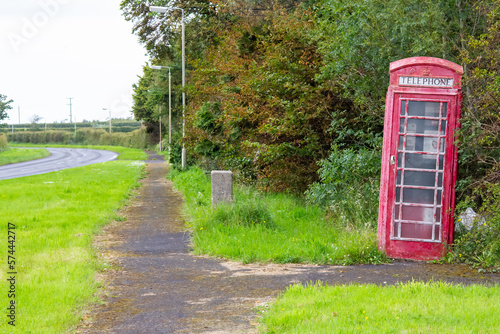 The leaning phone booth along the side of the road.