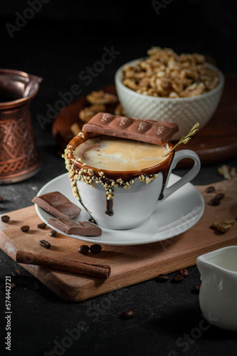 Cup of coffee with chocolate on dark background