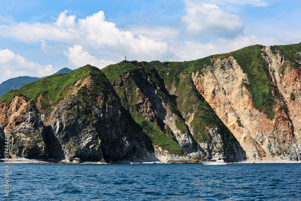 Mountains with green landscape in the Pacific Ocean on a clear sunny day. Kamchatka.