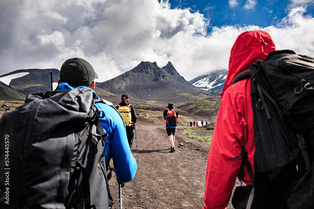 A group of tourists goes uphill, trekking, summer, sunny day. against the backdrop of Mount Camel, Kamchatka, Volcano. A group of tourists goes uphill, trekking, summer, sunny day. against the backdrop of Mount Camel, Kamchatka, Volcano.