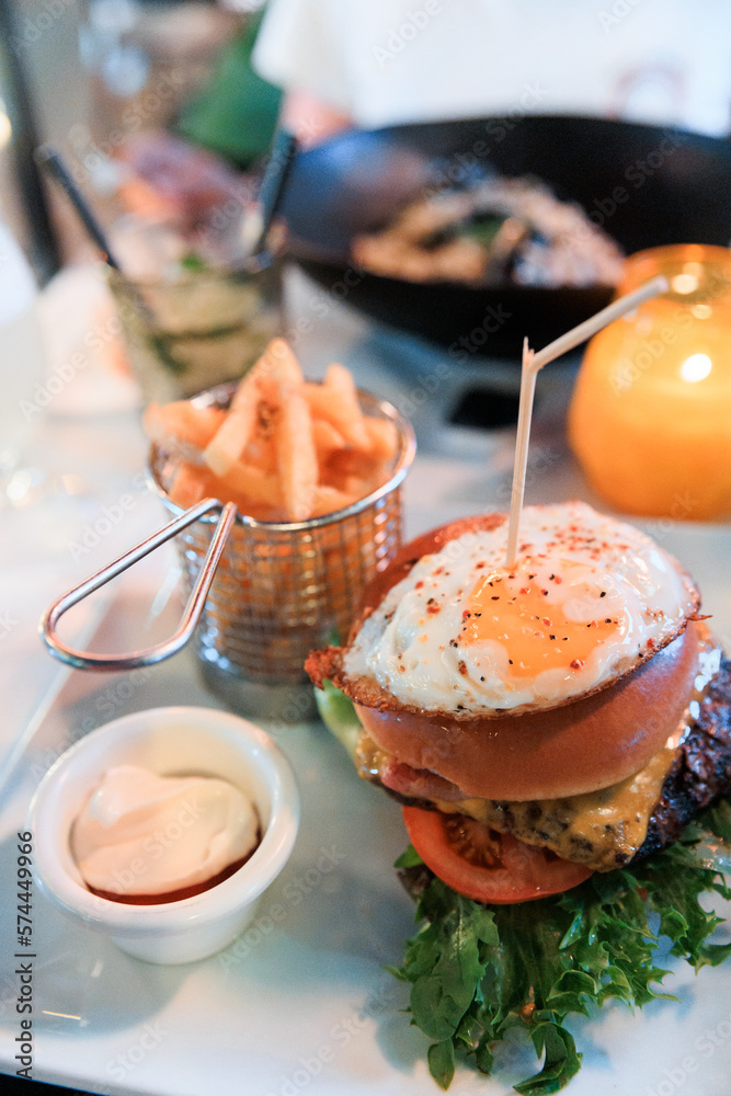 Delicious burger with fried egg and french fries