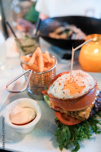 Obraz na płótnie Delicious burger with fried egg and french fries w salonie