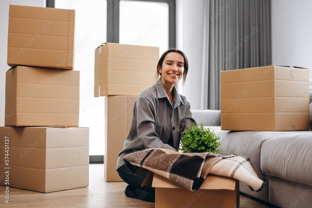 The girl moved to a new house and takes out her things from the boxes. The girl moved to a new house and takes out her things from the boxes.