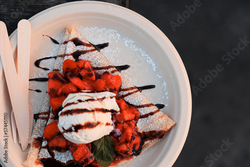Obraz na płótnie One scoop of vanilla ice cream on top of strawberries on top of crepe with chocolate and powdered sugar w salonie
