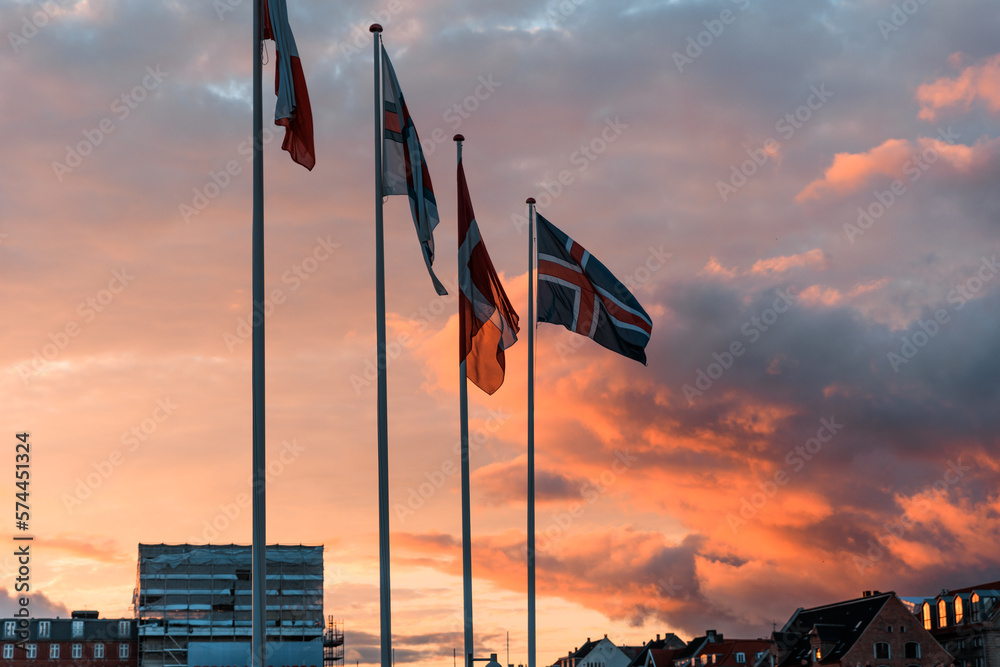 Scandinavian flags in front of epic sunset blowing in the wind in Copenhagen, Denmark