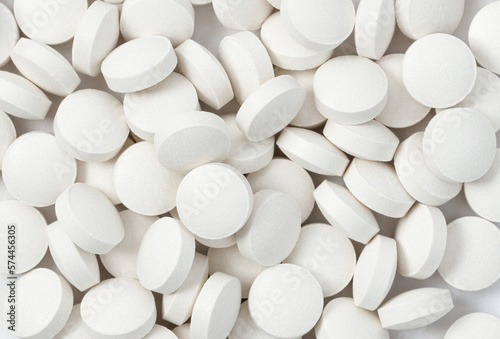 Heap of medicine white pills, antibiotic tablets, drugs. Pharmacy theme. Close-up, macro, top view