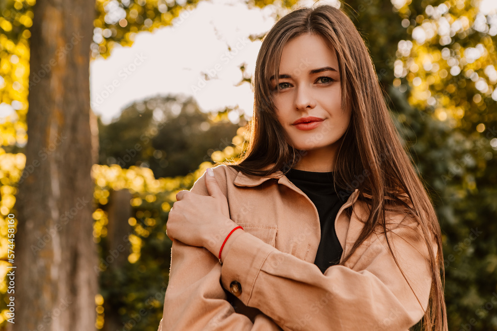 Caucasian young pretty stylish woman standing outside street dressed brown trench coat smiling poses outside city, spring autumn season nature sunshine light leaks. Cute brunette hair lady
Caucasian young pretty stylish woman standing outside street dressed brown trench coat smiling poses outside city, spring autumn season nature sunshine light leaks. Cute brunette hair lady