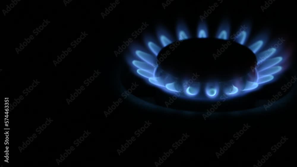 Gas stove burning, on dark background, space for text, close-up. Gas stove burning, on dark background, space for text, close-up.