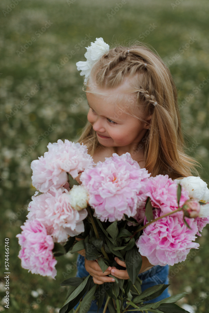 Beautiful little girl with big peonies bouquet. Spring blossom and carefree childhood concept. Beautiful little girl with big peonies bouquet. Spring blossom and carefree childhood concept.