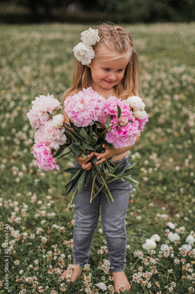 Beautiful little girl with big peonies bouquet. Spring blossom and carefree childhood concept. Beautiful little girl with big peonies bouquet. Spring blossom and carefree childhood concept.